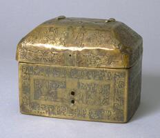 This inlaid bronze casket with Kufic inscription was masterfully produced in the 12th century Seljuk period. Possibly of Syrian origin, the lid is hammered from a flat sheet of brass with the bottom formed by folding and joining a section cut from a flat sheet. The seams are on three sides of the base and in the rear under the right-hand hinge. Brass hinges on the object are attached by copper rivets. Originally, the object would have a handle and front clasp which are now missing. <br /><br />
 