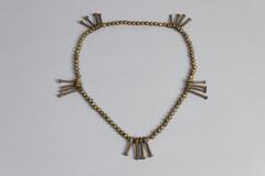 Belt with brass beads and five sets of four nail-shaped pendants. 