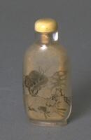A glass snuff bottle with painted hunt scene on the interior. The scene shows two hunters on horseback chasing and animal in an open field with a tree in the distance. On the top of the snuff bottle is a mouthpiece with an ivory stopper.