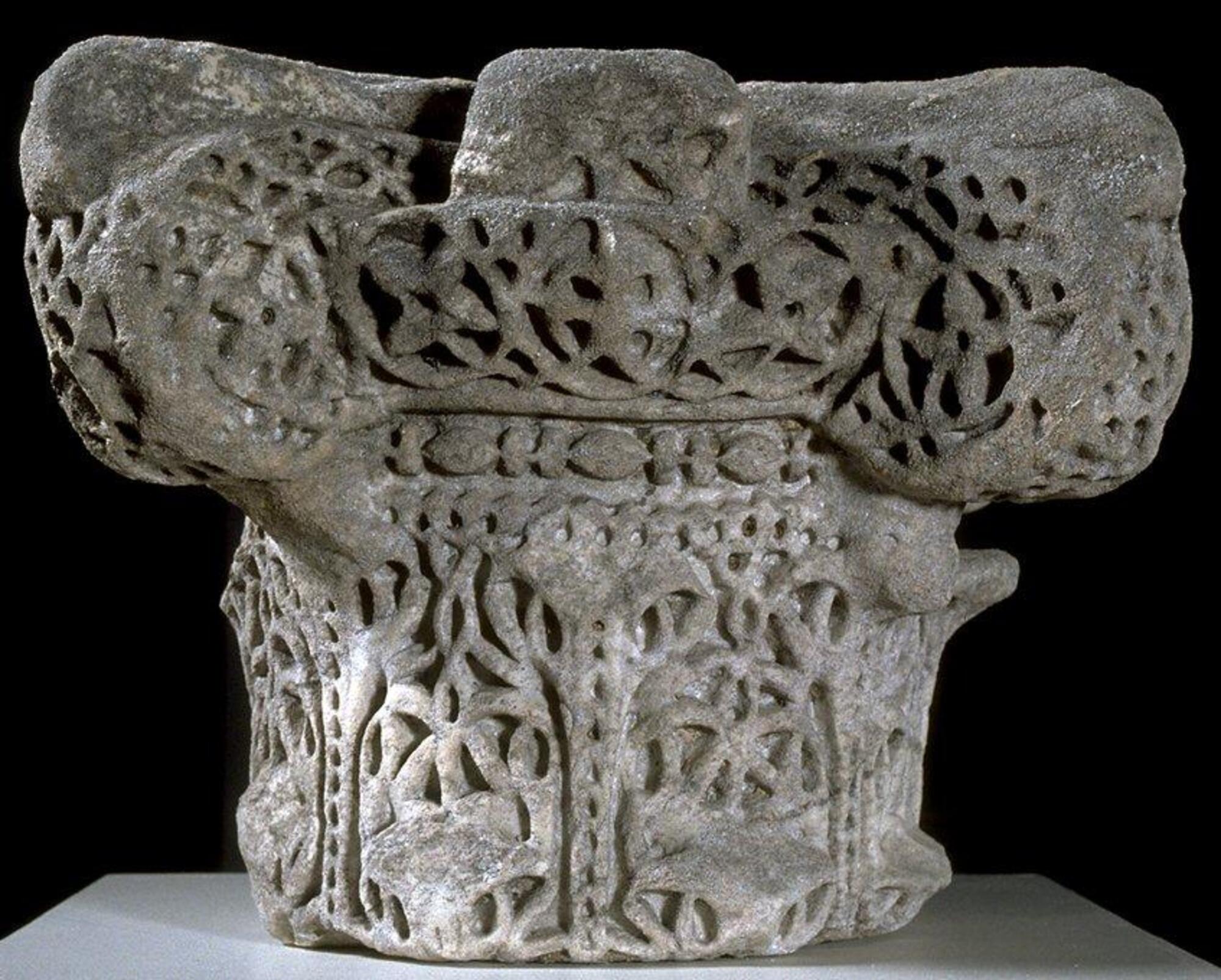 This capital, based upon the Roman composite order, features stylized acanthus leaves and rinceau on the bell of the capital, which terminates in a band of bead-and-reel motif on the astragal. This, in turn, is capped by an echinus decorated with three fleurons and vine rinceau on each face as well as four projecting volutes also decorated with rinceau and fleurons. Originally the bell of the capital had two tiers of acanthus leaves, but the capital has been cropped below the top of the first tier and the tips of the leaves, which once curved outward from the surface of the capital, have been sheared off.