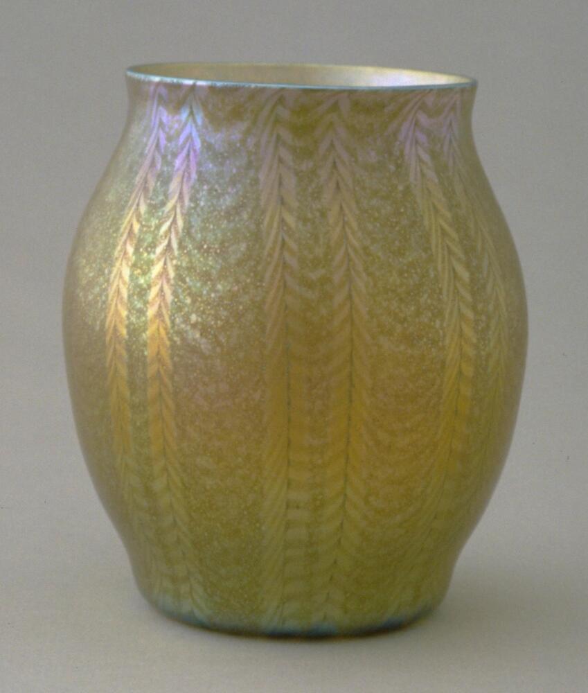 Glass vase with wide body and neck and slightly flared lip with irridescent golden yellow surface treatment in vertical leaf or feather design