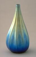 irridescent green and blue teadrop-shaped vessel with vertical ribbing
