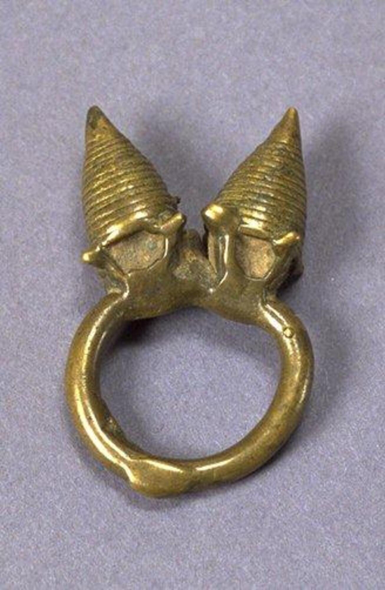 Ring with two conical projections, decorated with concentric horizontal grooves and a large loop.