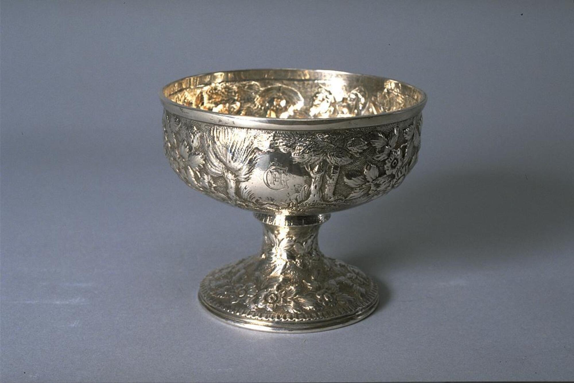 Silver vessel with bowl-shaped body, stemmed foot and opulent repouss&eacute; decoration
