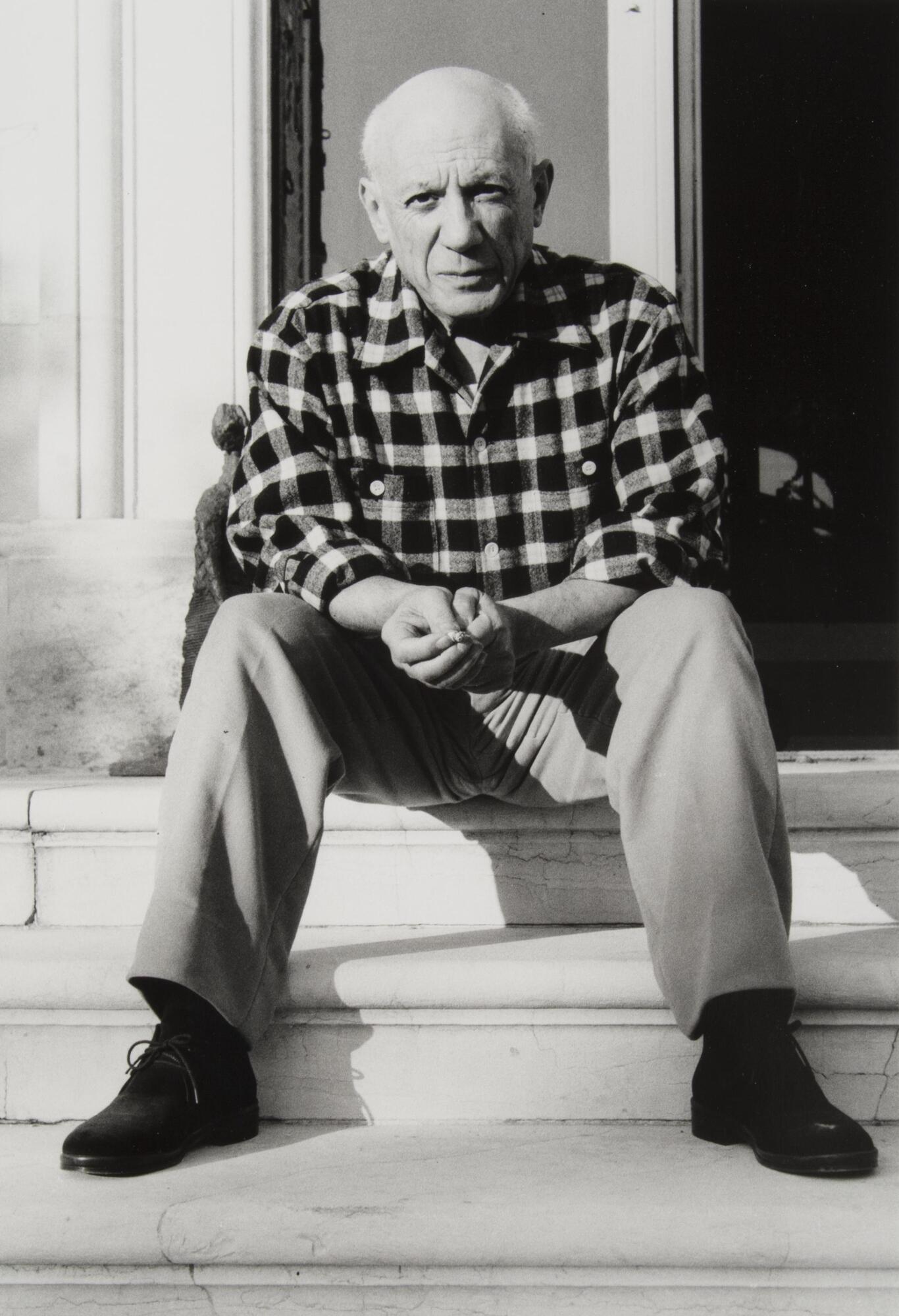 This portrait of a man shows him sitting on a set of steps, hands clasped between his knees. He wears a checkered shirt and long trousers.<br /><br />
EWP, 7/26/16: removed proper name, more appropriately addressed in SM