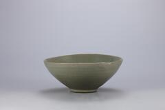 <p>Displaying a good sense of overall balance, the bowl&rsquo;s glaze is also quite clear and green. It was fired after the entire foot was glazed and placed on three quartzite supports. There are marks of glaze running on both the inside and outside of the bowl, leaving an uneven surface. Bowls fired on quartzite spurs such as this one were mostly high-quality items. Apart from damage in two parts of the mouth, this piece is preserved in near-perfect condition.<br />
[<em>Korean Collection, University of Michigan Museum of Art</em> (2014) p.98]</p>
It has a slightly outward flared rim and tapers abruptly to a narrow base. It has no underglaze decoration. There are three spur marks in eye. The glaze is greenish blue in color, leaning toward green, and the base clay contains some impurities.