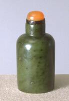 A green cylindrical nephrite jade snuff bottle. The stopper is orange glass.