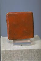 Square ceramic tile with orange glaze