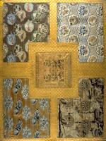 A checkered gold brocade foregrounds five fragments of textile: a square in the middle surrounded by four cornerpieces. Each textile has a different design, some with butterflies, birds, and other floral motifs.