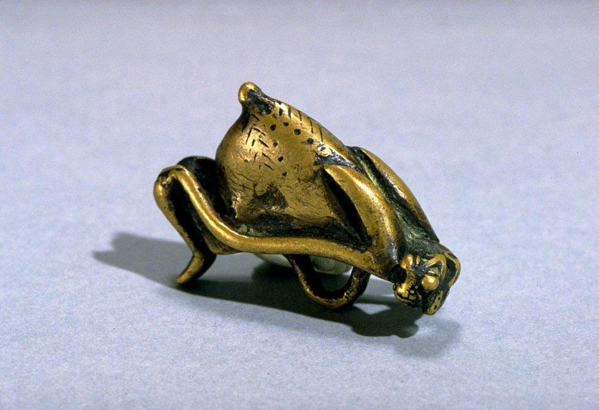 Pendant in the form of a pregnant woman holding her stomach. 