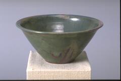 Inverted cone-shaped bowl with flat rim and iridescent green glaze