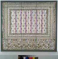 Firescreen consists of a rectangular metal frame with glass and metal elements set in rectangular (largely geometric) framing patterns around a central panel of white and purple vertical glass rods. Along the bottom is a border of white, amber, and green glass circular elements in a more naturalistic pattern evoking grapes.