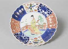 A scalloped plate with a design of a lady in a yellow dress, standing in a garden.