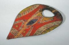 Tear drop shaped mask with geometric painting.  Red, yellow, blue and white linear details.