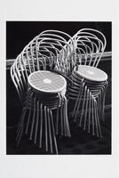Two sets of eight metal chairs are stacked and chained to one another.