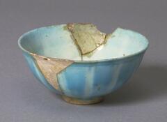 A deep bowl seriously damaged with sections missing.