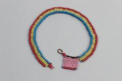Beaded jewlery made up of two rows of yellow beads, with an outer row of red beads and two inner rows of blue beads. Beaded square on one end of pink beads with red edge and black edge. White tag attached, brown loop at end with square.