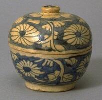 A round ceramic box (that is, a bowl with a fitted lid), decorated with chrysanthemum scrolls drawn in blue outline against a blue background. The blue is cobalt pigment painted before the application of a clear glaze.