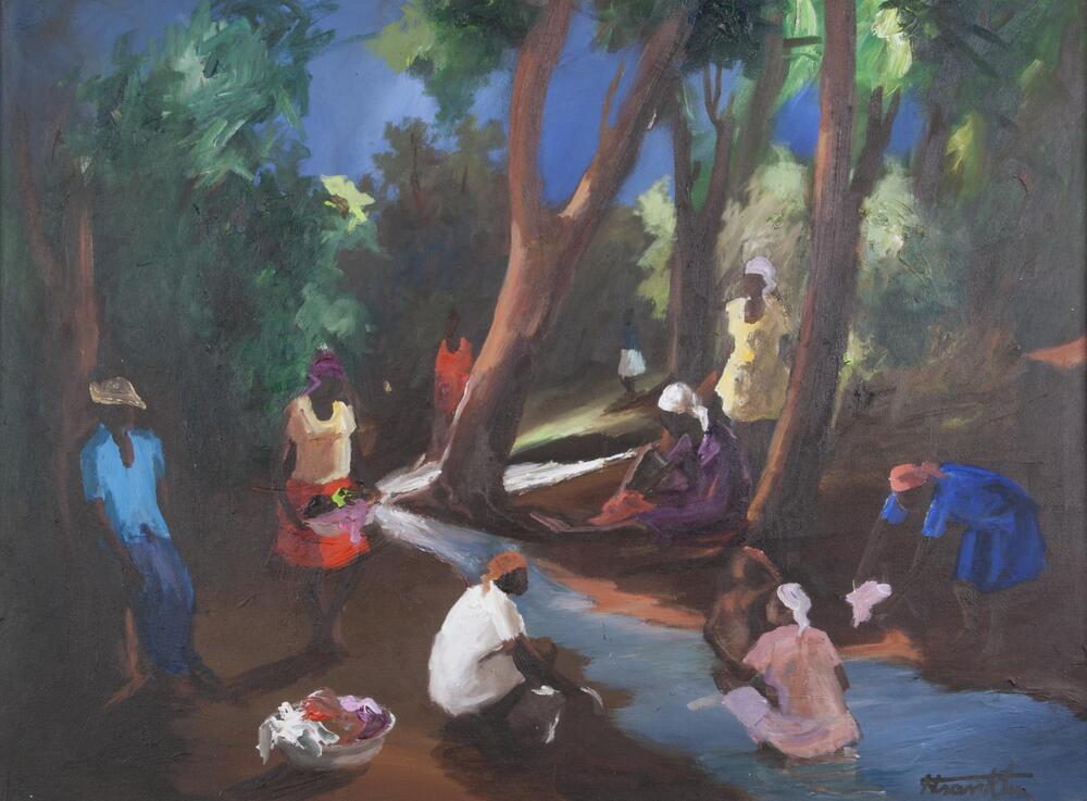 A group of women gather to wash clothes in a river while a man looks on.