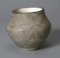 This is a wide-bellied, small pot with slightly concave shoulders. The pot's mouth is slighlty wider than the foot. A black pattern is painted on a white surface: this complex, linear design starts with a very small triangular path and winds around itself again and again like a maze. Mazes meet to form eight-pointed intersecting star pattern.