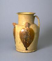 A stoneware ewer with an straight sided body and a rounded shoulder.  It tapers slightly towards the foot.  On top of the shoulder is a straight, tall neck with an everted rim.  There is a coiled handle extending up from shoulder neck junction towards rim, then curving back down and attached to shoulder.  Opposite of the handle is a short faced spout, and in between the handle and spout are two loup lugs applied to the neck-shoulder junction. Below the lugs and spout are sprig molded and applied images of Central Asian dancers and musicians, covered entirely in a straw-celadon glaze with brown glaze applied to the danceers and musicians. 