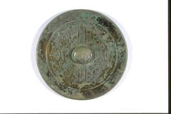 bronze mirrorr with two columns of auspicious inscriptions for career promotion and healthy offsprings in eight characters separated by the central knob, which is, in turn, surrounded by stylized mystical animal motif on both side.