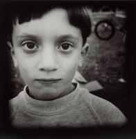 An up-close image of a boy's head, he is wearing sweatshirt. The edges of the image are darkened.