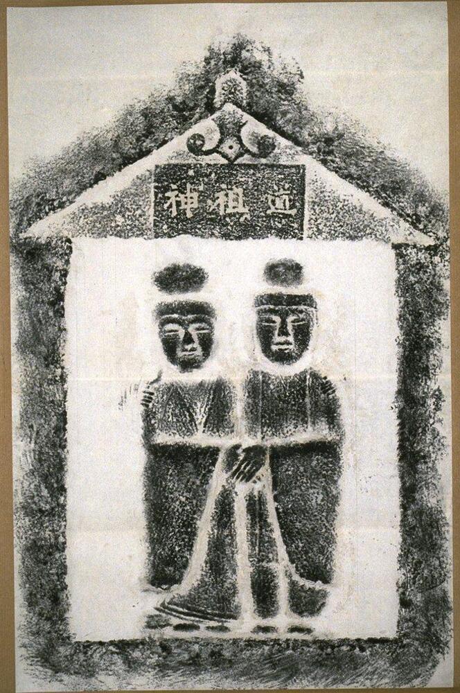 An image of two figures holding hands under a roof. The figures also have their arms wrapped around each other's shoulders. There is writing on the roof with the kanji for 'kami' 'ancestor' and 'road'