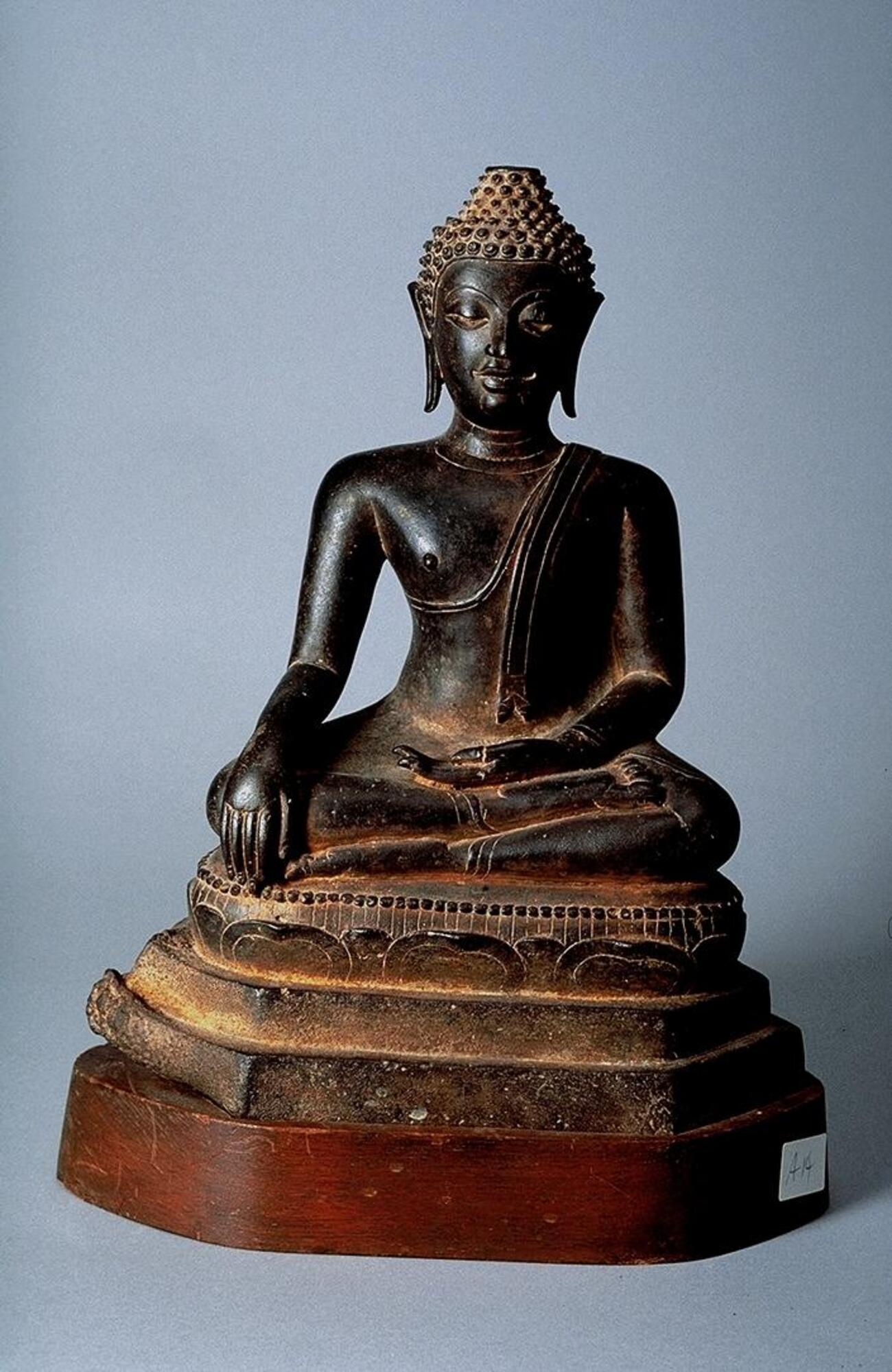 The Buddha in bhumisparsa mudra (the gesture of touching the earth with his right hand, palm inward), signaling his victory over Mara. In Southeast Asian contexts, this hand gesture is often referred to as Maravijaya mudra, or &quot;victory over Mara.&quot; The Buddha&rsquo;s elongated earlobes refer to his early life as a prince, when he wore heavy earrings. Texts that describe how a Buddha&rsquo;s face should look often use comparisons to natural forms such as eyes like lotus petals, eyebrows like an archer&rsquo;s bow, and a chin like a mango stone. The artist who created this sculpture clearly followed similar instructions.