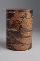 A wooden tea canister with lid. The sides of the canister have an intricate design of mountains, trees and water inlaid to the wood.The shape is tubular and the lid is the same diameter as the base.