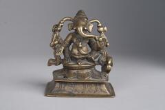 A bronze statue of an Hindu god. The figure has an elephant head attached to a human body.