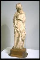 This marble statue depicts a standing male figure, who holds a closed book in his left hand and makes what appears to be a gesture indicating speech with his right. The curls of his flowing beard and long hair are echoed in the gentle curving folds and undulating edges of his long robe and mantle. He turns his head downward and to his left