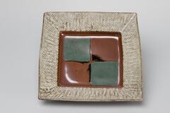 Square plate with a gray mishima-style border around the edges. The center is divided into four squares, two green and two brown.