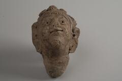 Indian terracotta head figure looking up, with detailed facial features and facial expressions.