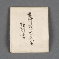 A handwritten certificate in calligraphy on a square piece of paper. On one side there is writing in the middle of the paper. On the reverse side, there is writing in the middle of the paper with a stamp on the bottom left corner of the paper.