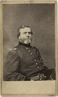 Half-length, seated portrait of a bearded man in a military uniform.