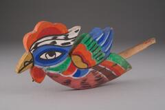 An ornament in the shape of a colorful bird, cut out of a single piece of wood and painted on both sides. A piece of bamboo has been nailed to the wing so that it could be inserted into a hole on the funeral bier. The bird has a blue face with green, white, red, orange, and yellow colorations over the body.<br />
<br />
This funeral bier ornament is made of a piece of wooden panel cut into the shape of a mythical bird called bonghwang and painted on both sides. A piece of bamboo has been nailed to its wing for insertion into a hole on the funeral bier. The species of the wood used is unknown.
<p>[Korean Collection, University of Michigan Museum of Art (2017), 218]</p>
