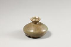 <p>This is an intact hair oil bottle; an invaluable source for the information it provides about the form of Goryeo celadon oil bottles. The foot was made by removing the clay from the bottom of the base, while the foot rim shows the trase of glaze having been wiped away and has small grains of sand ahered to it. Glaze was oxidized in parts, yielding a yellow-brown color, and fine crackles are formed on the glazed furace. Glaze was poorly fused and there are glaze runnings on the lower part of the body.<br />
[<em>Korean Collection, University of Michigan Museum of Art</em> (2014) p.129]</p>
