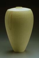 A vessel of bleached wood. From a narrow base, the vessel widens gradually. Near the top it begans to narrow gradually then narrows quickly on a nearly horizontal plane to a very small mouth. The surface, apart from the smooth lip of the mouth, is finely textured with vertical scoring.<br />
light-colored wood vase with textured hatching across surfaces