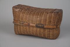 A rectangluar box woven with bamboo. There is a strip of bamboo with a clasp to keep the basket closed and in one piece. Used as a fermer&#39;s lunchbox.<br />
<br />
This lunchbox is woven from strips of bamboo. The outer part is plain-woven, while the inner part is woven in the style of a reed mat. The frame is made from bands of bamboo tied together in two places. Lunchboxes such as this one were used to deliver meals to those working in fields.
<p>[Korean Collection, University of Michigan Museum of Art (2017) p. 278]</p>
