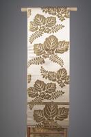 Maru obi with ivory colored sateen weave silk (shusu) with large woven paulownia designs in gold-leafed paper (kinran)