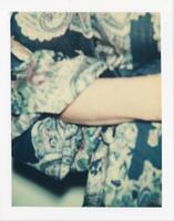 An out-of-focus photograph of a woman’s arm and the pattern of her floral dress.  