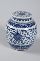 A blue-and-white covered jar and lid with floral scroll design.