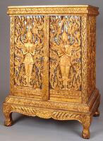 Manuscript cabinet decorated with two celestial beings making the gesture of worship and respect (anjalimudra) on front doors. The hands and faces of these figures are carved in particularly high relief, making them seem to interact with the worshipper, a feeling enhanced by the reflection of the background inserts.