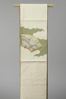 <p>gold-speckled pale green and cream colored Nagoya Obi with interwoven clouds with patched, gold-embroidered, and orange Oogi (fan) motif depicting a female figure wearing a red and blue kimono and holding a folding fan. There are illegible kanji written on one of the fans.</p>
