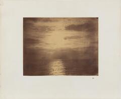 Seascape depicting a cloud-filled sky over the ocean with sunlight reflecting on the rippling water.