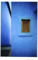 A photograph of blue walls. The framing of the image emphasizes the geometric planes, texture, and color of the walls.