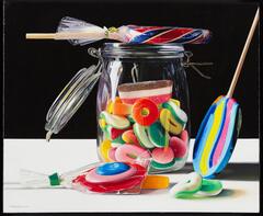 A still life of a colorful display of candy, some wrapped, some in a jar, and some loose on a white surface.