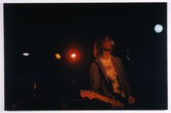 Photo of a figure looking like Kurt Cobain performing onstage.