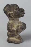 Crouching or seated female figure with an elongated face that tilts backwards. The figure is holding her breasts and has a distended stomach and deep navel. 